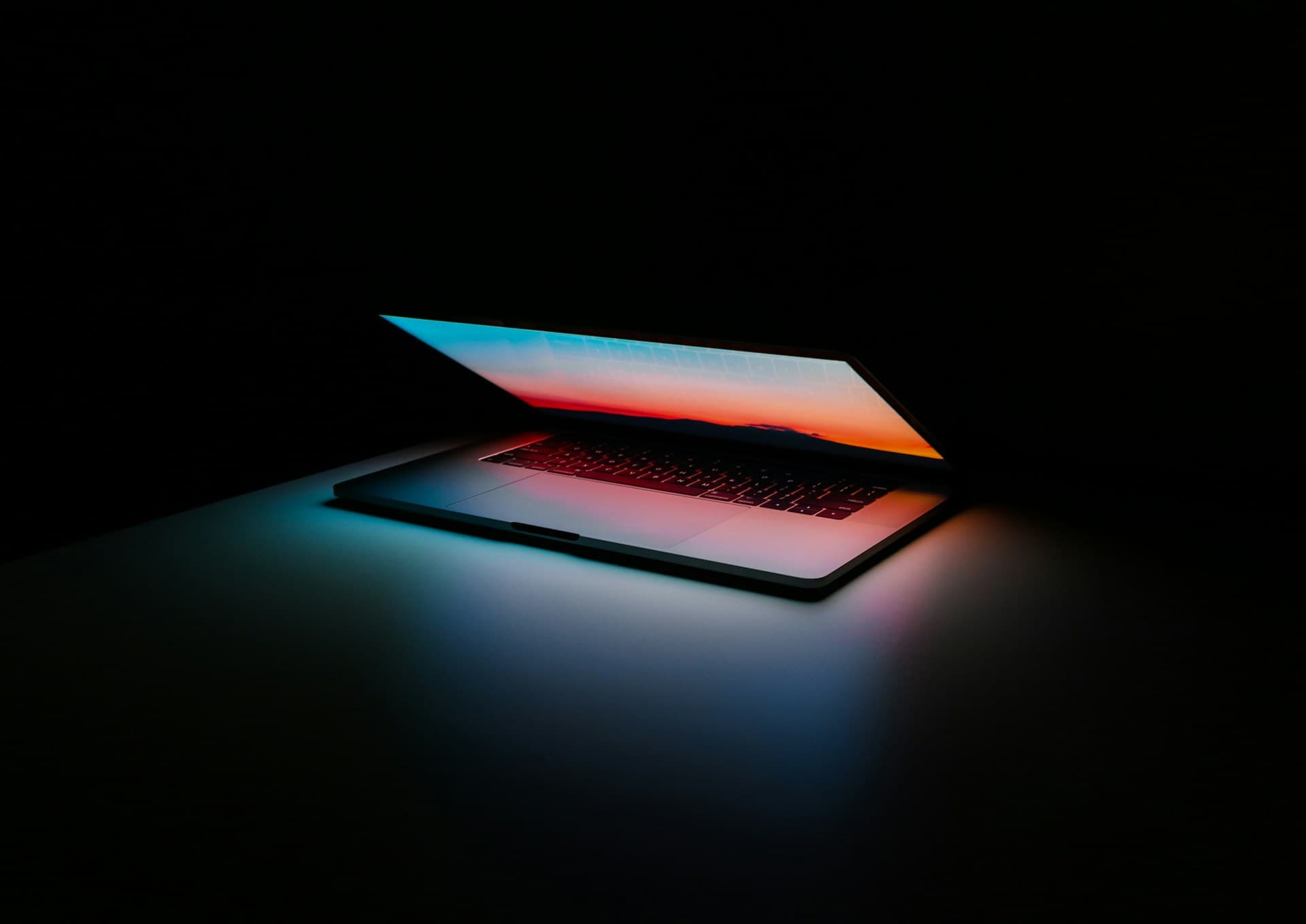 A laptop illuminated against a dark background